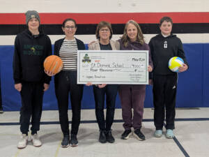 Image of Humboldt Broncos memorial Golf Tournament giving a Legacy Donation to St. Dominic School for their new scoreboard/clock for their gymnasium